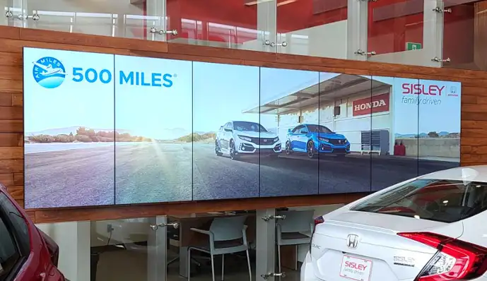 A large video wall installed in a commercial interior, viewed from across the room