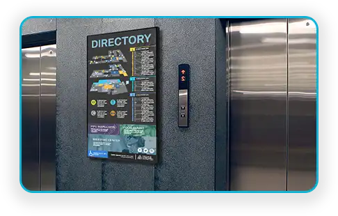 Office tower directory screen beside an elevator bank for corporate wayfinding