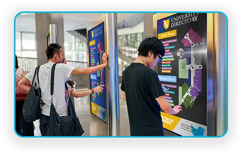 Students using an interactive campus directory and wayfinding screen
